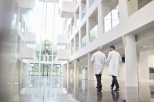 Two doctors walk down the atrium of a hospital. Grand Rapids Epoxy Flooring